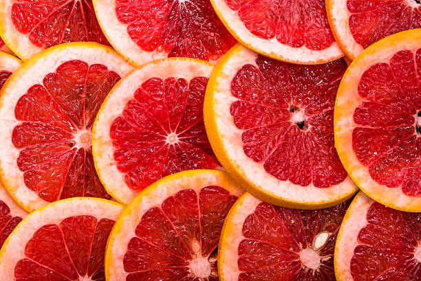 istock Sliced grapefruits, background, natural texture of citrus, top view, close-up 623289608