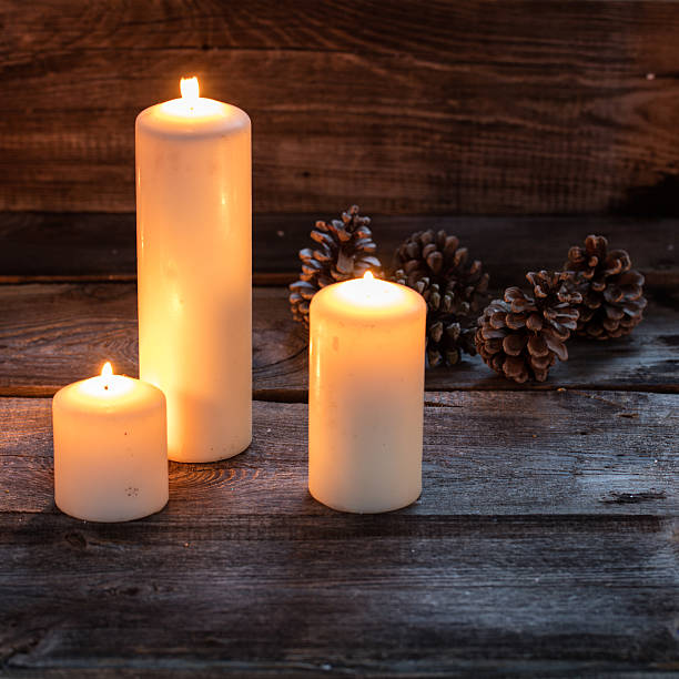 istock winter candlelight background with glowing big candles on rustic wood 623289992