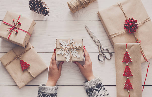istock Woman's hands wrapping christmas holiday present with craft twine 623292528