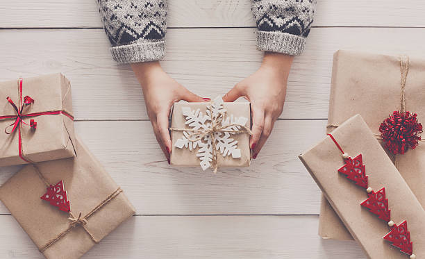 istock Woman's hands show christmas holiday present with craft twine 623292594