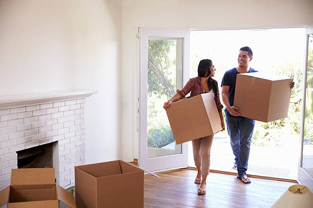 Couple Carrying Boxes Into New Home On Moving Day Couple Carrying Boxes Into New Home On Moving Day unpacking photos stock pictures, royalty-free photos & images