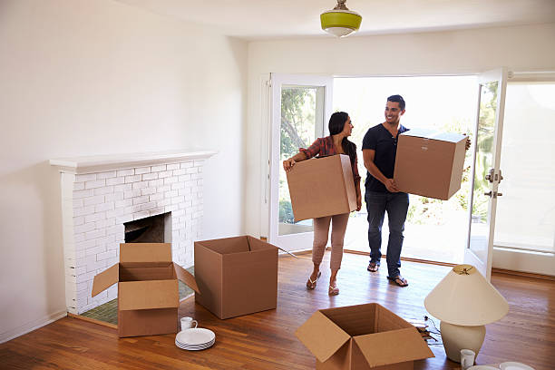 istock Couple Carrying Boxes Into New Home On Moving Day 623294404