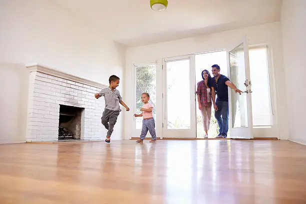 Photo of Excited Family Explore New Home On Moving Day