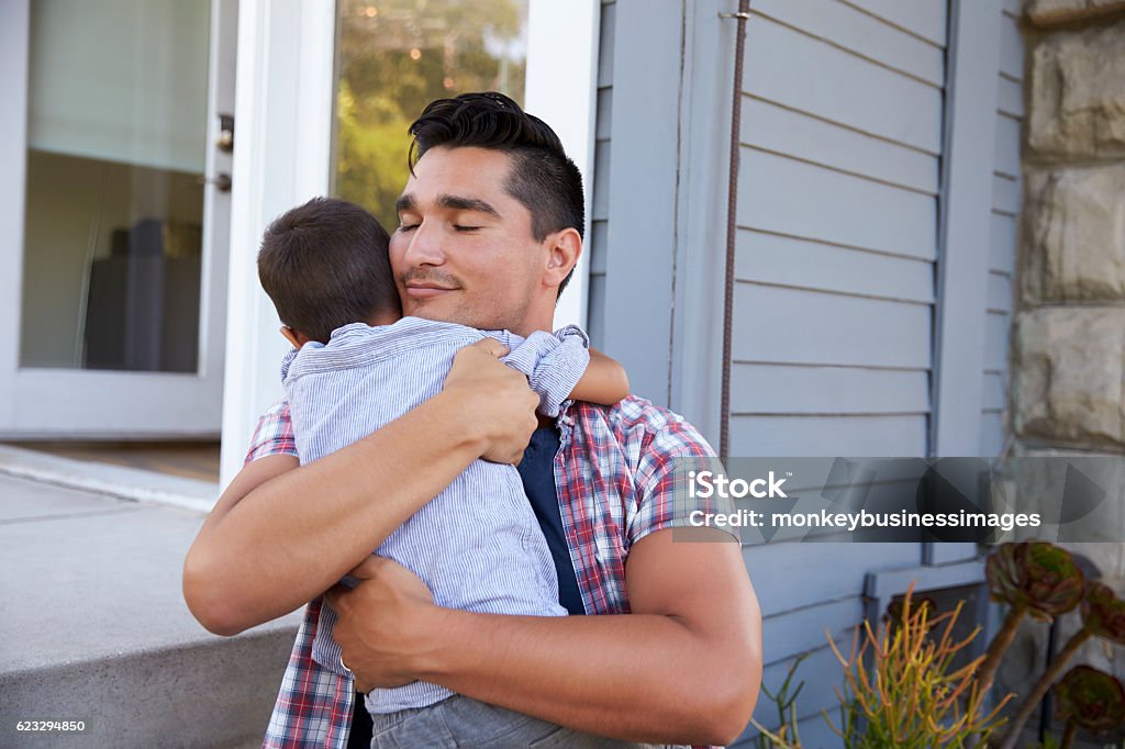 Padre abrazando Hijo sentado en pasos fuera de casa - Foto de stock de Padre libre de derechos