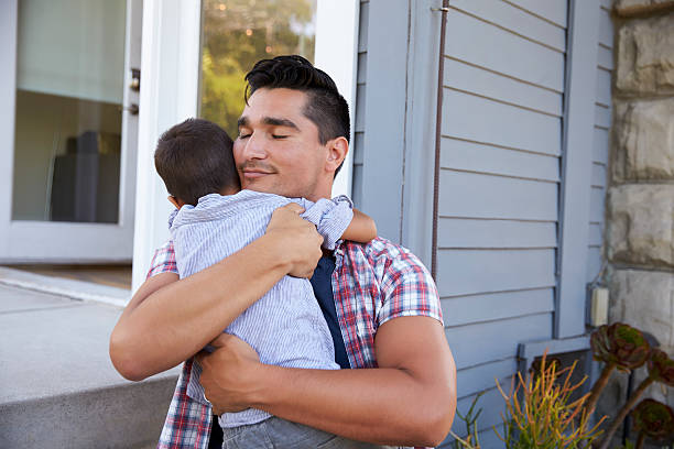 Father Hugging Son Sitting On Steps Outside Home Father Hugging Son Sitting On Steps Outside Home southern california photos stock pictures, royalty-free photos & images