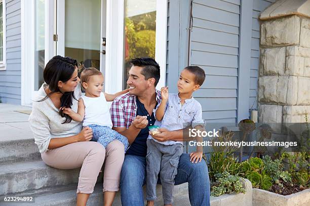 Father Giving Children Candy On Steps Outside Hose Stock Photo - Download Image Now - Family, Domestic Life, Latin American and Hispanic Ethnicity