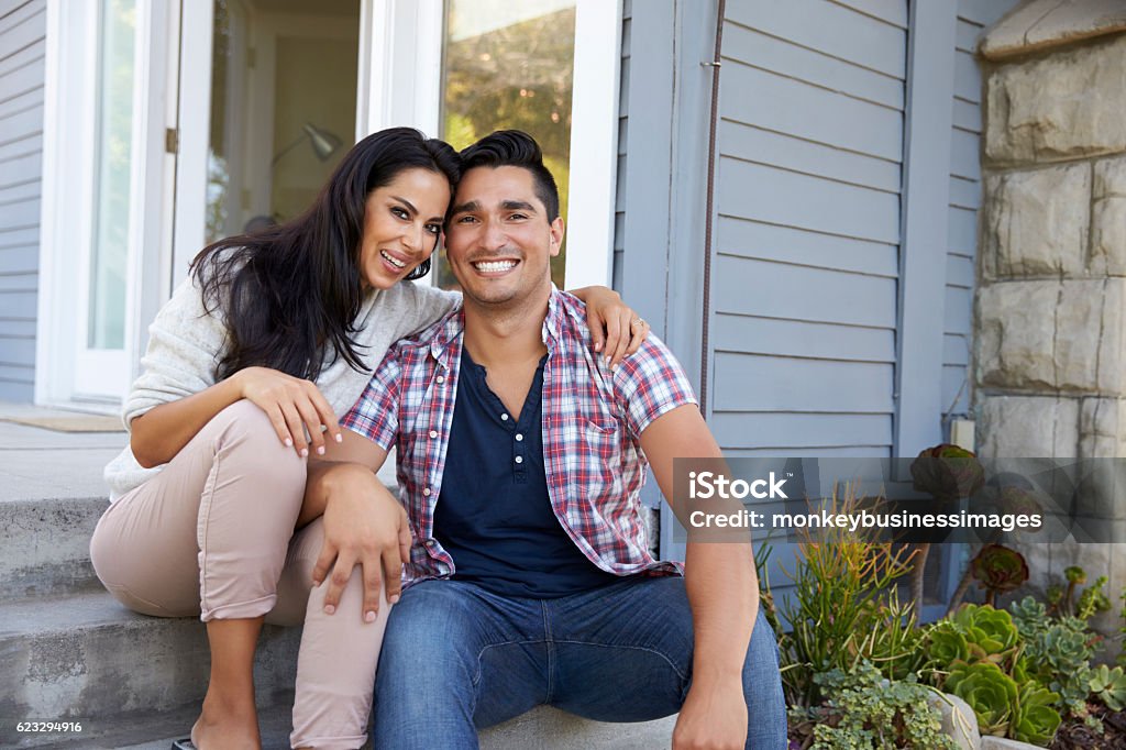 Ritratto di coppia seduto sui gradini fuori casa - Foto stock royalty-free di Relazione di coppia