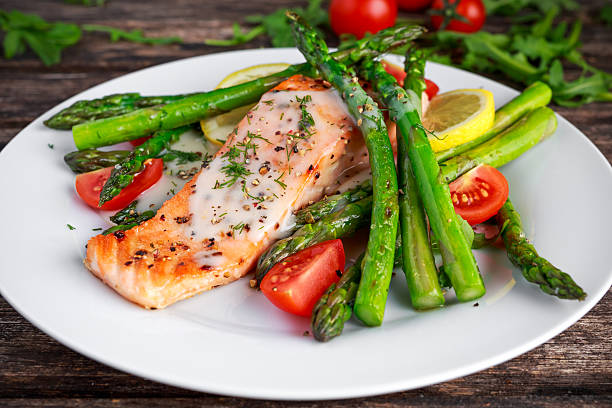 istock Fried salmon with asparagus, tomatoes, lemon, yellow lime on white 623295608
