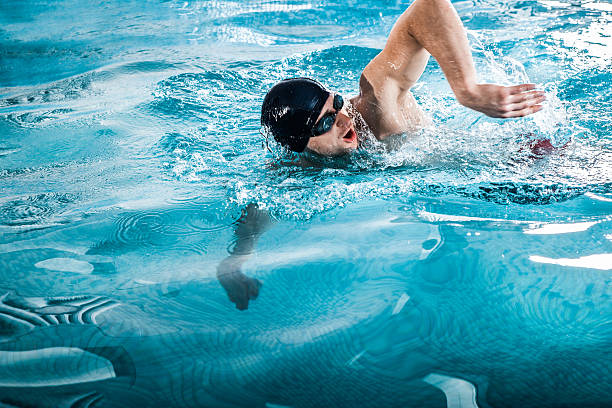 istock Young man swimming the front crawl in a pool 623296068
