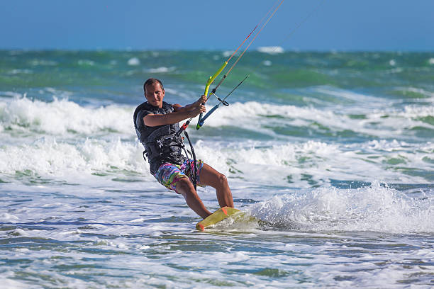 istock Athletic man jump on kite surf board sea waves 623301072