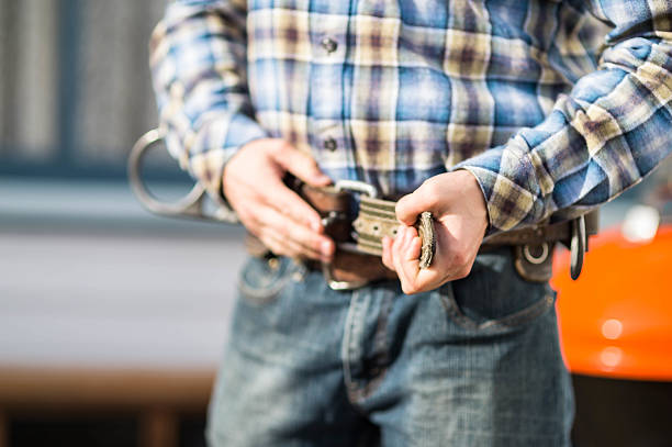 istock Adult male construction worker putting on work belt 623303116