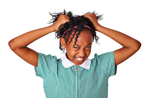 Portrait of frustrated little girl pulling her hair against white background