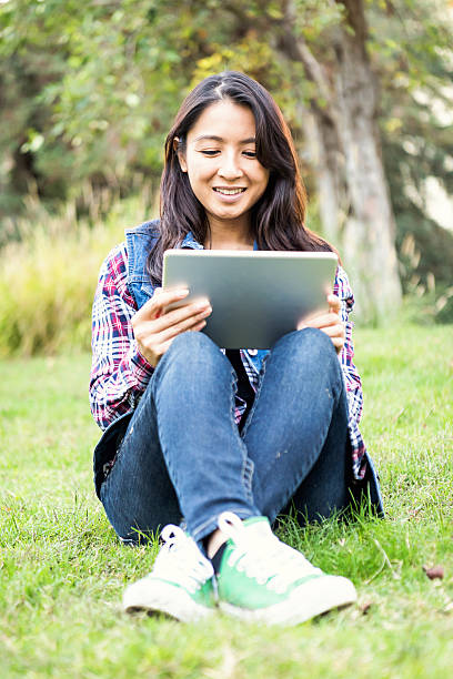 istock Smiling asian woman looking at her digital tablet 623304098