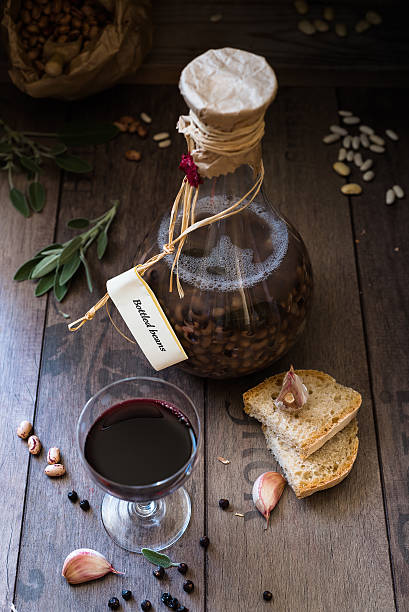 beans cooked in a bottle, rustic bread and red wine Italian food: beans cooked in a bottle with sage and garlic, rustic bread and glass of wine lavagna stock pictures, royalty-free photos & images