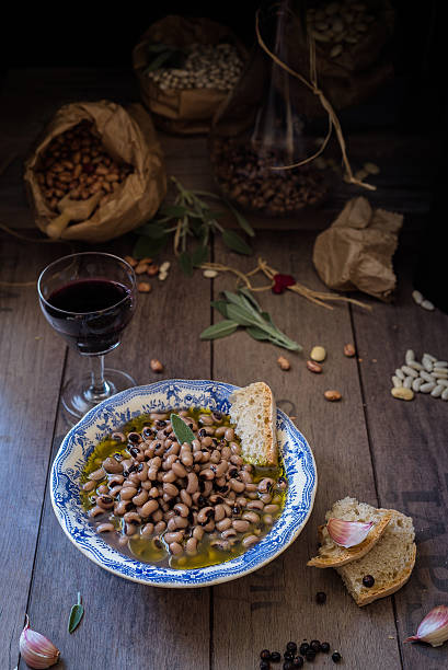 beans soup, slices of homemade bread and glass of wine boiled beans seasoned with olive oil, sage and garlic; slices of homemade bread and glass of red wine on rustic background lavagna stock pictures, royalty-free photos & images