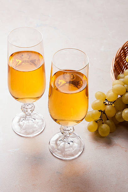istock White wine and grapes. White wine in glasses and grapes 623343566