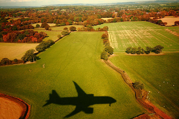 Landing shadow Shadow of passenger jet seen from a Boeing 787 cast onto scenic landscape whilst approaching Gatwick Airport, London, United Kingdom.  gatwick airport photos stock pictures, royalty-free photos & images