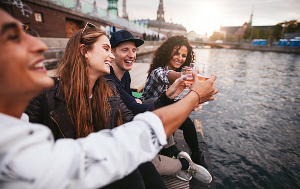 istock Group of young people having drinks at lake 623344742