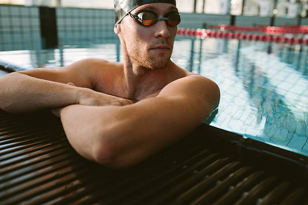 istock Pro male swimmer relaxing at pool edge 623345690