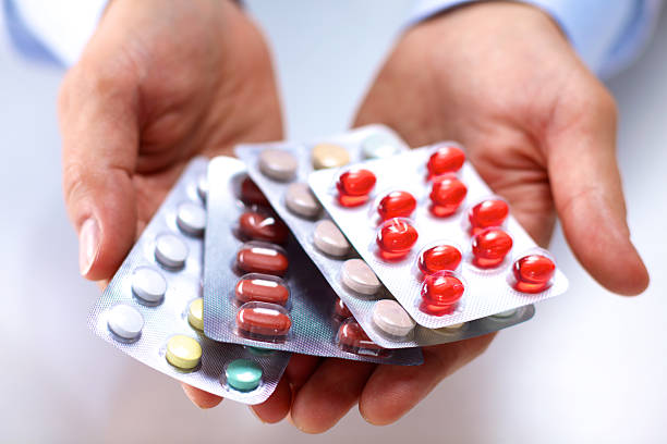 istock young doctor holds the patient's hand with pills 623348094