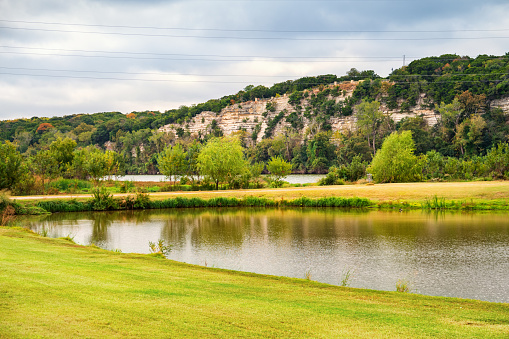 Photo of Brazos Park East with the Brazos River and the cliffs of Cameron Park in the background in Waco, Texas, USA.