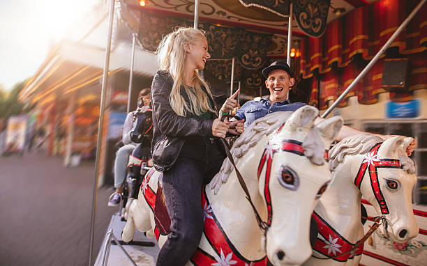 istock Young couple on amusement park carousel 623350608
