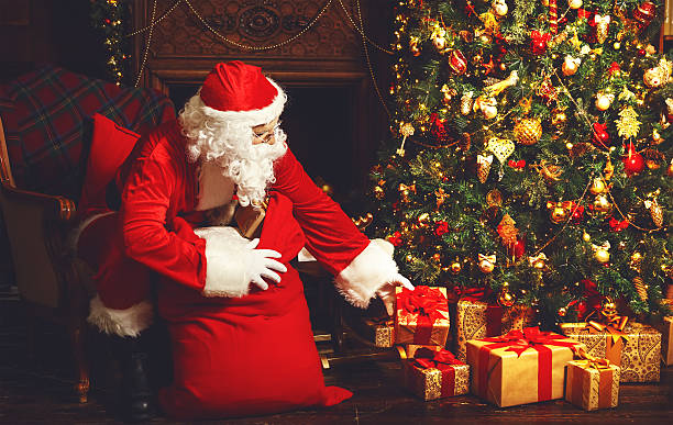 istock Santa Claus with gifts around Christmas tree 623356914
