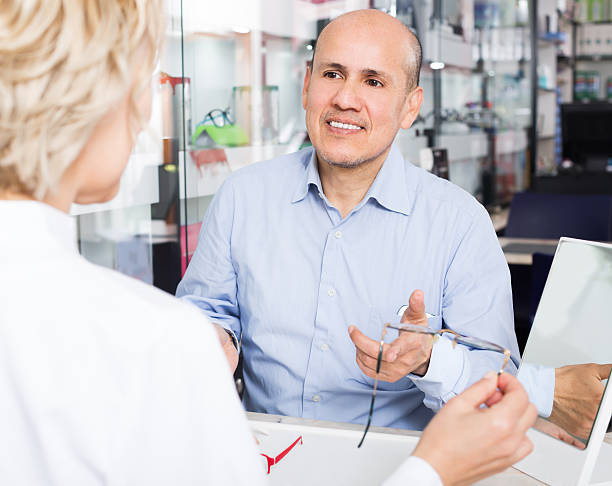 istock Mature consultant and male choosing glasses 623357056