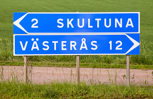Signpost with distancees to the two Swedish towns Skultuna and Vasteras.