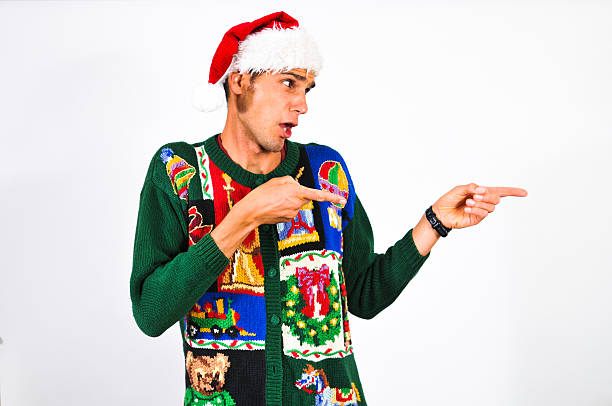 I choose you A young man wearing festive Christmas attire points. Horizontal image with copy space.  christmas ugliness sweater nerd stock pictures, royalty-free photos & images