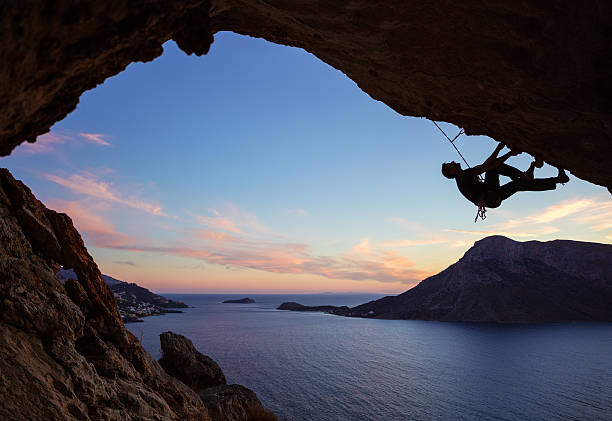 istock Male climber climbing along roof in cave 623359730