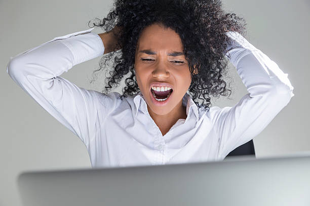istock Close up of African office employee crying desperately 623360192