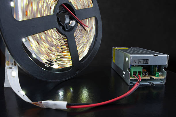 istock Closeup Shining LED Strip Light, near voltage converter,  black background. 623360766