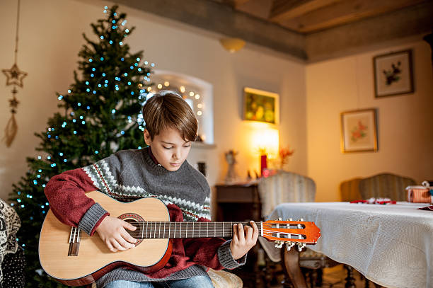 istock Little Boy Playing on Guitar on Christmas 623362718