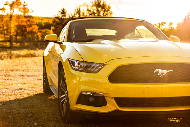 Flagstaff, Maine, USA - October 10, 2016: View of a yellow Ford Mustang GT convertible 2016 version parked on the countryside of Flagstaff in Maine at dusk. Ford Mustang is a sport coupe made by Ford.