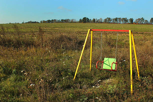 istock Empty swinging see saw in abandoned playground 623365404