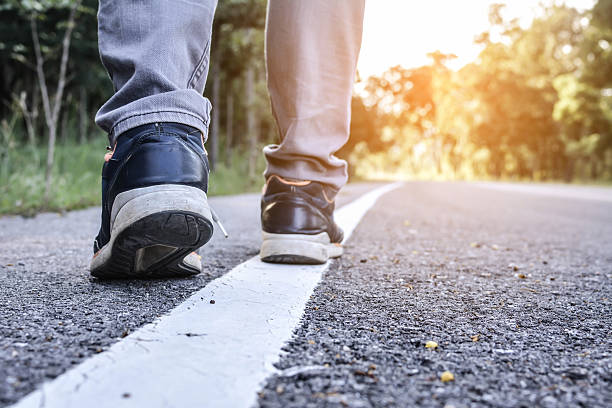 istock Feet of man on road and nature background 623367108