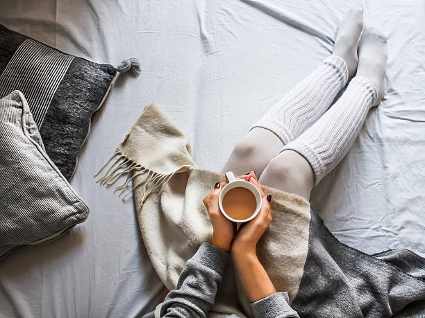istock young woman on a bad holding a cup of coffee 623367920