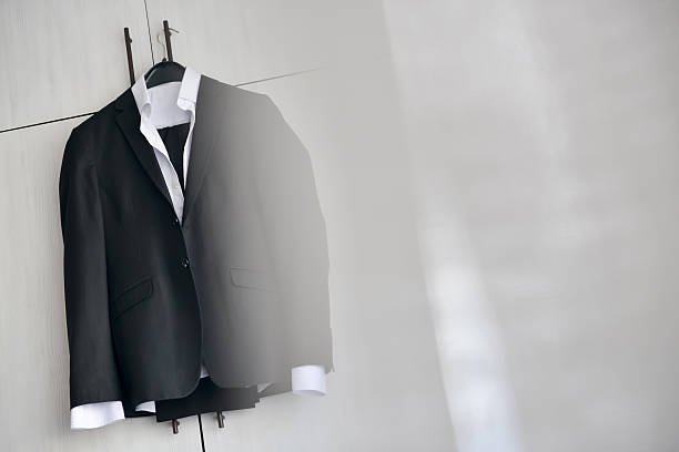 istock Black suit hanged to a wood closet in natural light 623373004