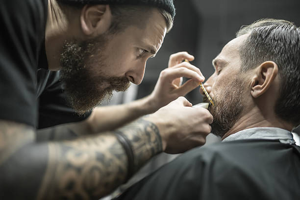 Trimming beard in barbershop stock photo