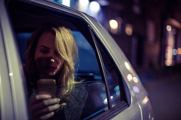 istock Business woman using phone in a car at night 623375140