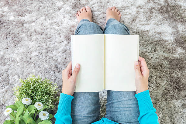istock Closeup woman sitting on gray carpet read a book 623375992