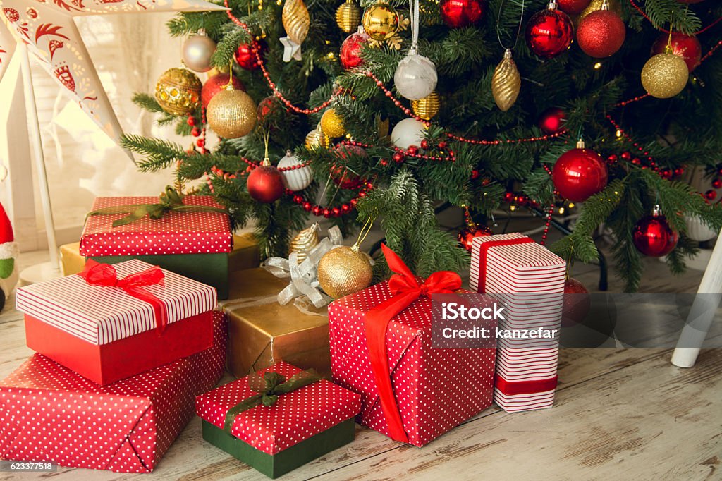 Gifts under a Christmas spruce Gifts under a Christmas under spruce on the wooden floor Gift Stock Photo