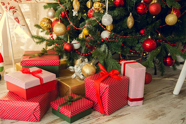 Gifts under a Christmas spruce Gifts under a Christmas under spruce on the wooden floor perfect gift stock pictures, royalty-free photos & images