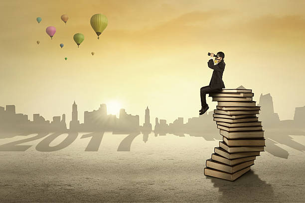 istock Male entrepreneur sits on books with 2017 623381876