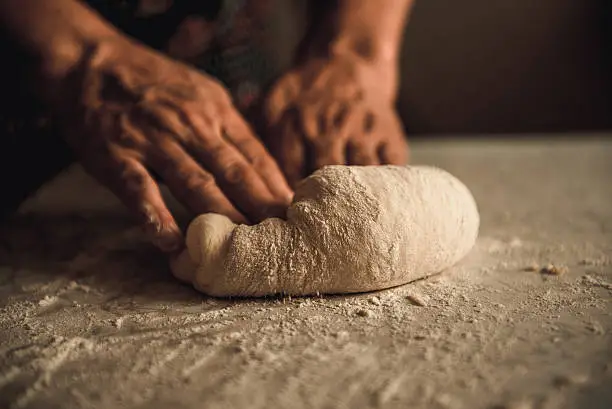 woman knead the dough by hand on pies