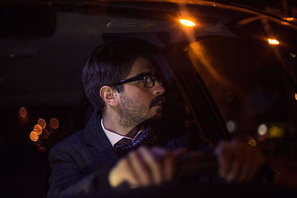 istock Man with mustache drivin a car at night road 623383288