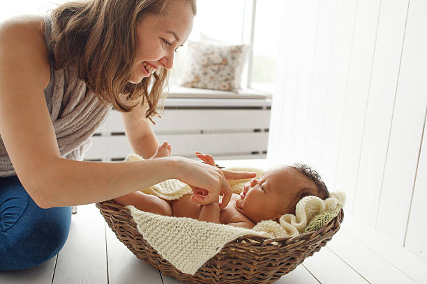 istock Smiling mother playing with newborn baby, profile 623383558