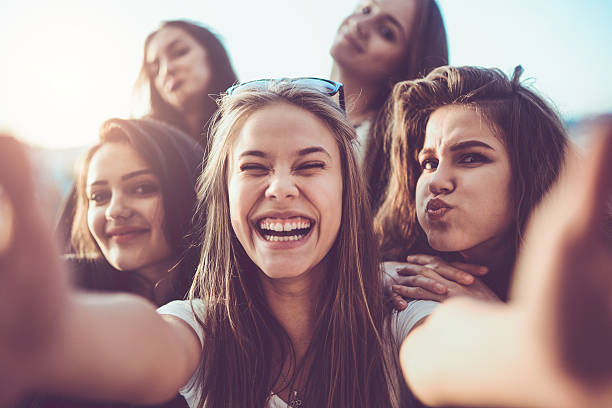 istock Group of Smiling Girls Taking a Selfie Outdoors at Sunset 623384154
