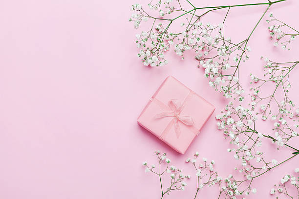 regalo o regalo con fiori su tavola rosa. lay piatto. - mothers day frame flower single flower foto e immagini stock